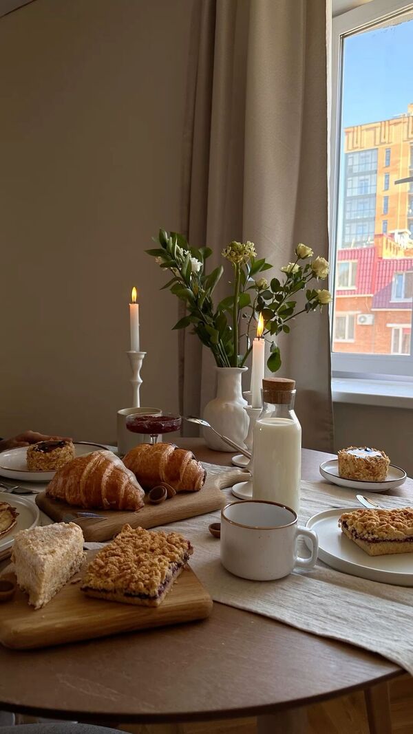 清晨的餐桌上放着麦片、面包和果盘，阳光从窗外照进房间，氛围安静柔和
